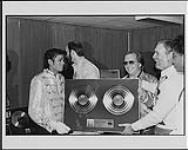 Michael Jackson reçoit du président de CBS Records Canada, Bernie Dimatteo, et de son vice-président des ventes et du marketing, Don Oates un disque double platine pour l'album « Victory » [entre 1984-1985]