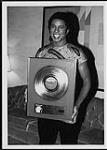 Jermaine Jackson tenant un prix pour son album Dynamite [ca 1984].