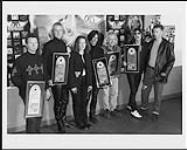 Portrait of the band Aerosmith receiving a Platinum award. Stephanie Robertson and Paul Eastwood from Universal Music stand with the band. Hamilton, Ontario October 24, 1998