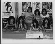 Portrait de Lee Aaron à une séance d'autographes au Record Stop de Sudbury. Aussi sur la photo : Jack Meli, George Bernhardt, John Albani, Derek Clark, Kathy Murphy et Randy Infuso [ca 1984].