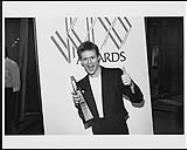 Portrait of Bryan Adams holding a Juno Award after winning in four catagories in 1984 1984