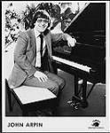 Press portrait of John Arpin sitting at a piano. Tembo Music Canada Inc [between 1965-1975].