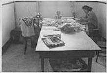 Woman seated at sewing machine in the Old Mission Hospital, Fort Simpson, Northwest Territories 1975