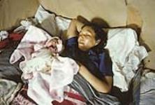 Femme autochtone au lit avec son nouveau-né drapé dans une couverture rose n.d.