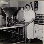 Woman working in a dairy ? [between 1930-1960].