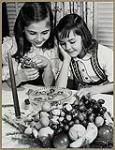 Deux jeunes filles tchèques cassant des noix à table [between 1930-1960].