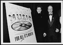 Celine Dion beside a 'Music for all it's worth' sign [entre 1995-2000].
