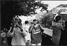 Earthtones, un groupe rhythm and blues de Calgary, joue de la musique sur un camion, dans une rue passante [between 1992-1997].