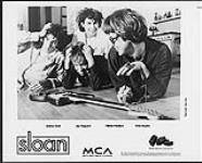 Photo publicitaire des membres du groupe Sloan allongés sur le sol avec une guitare (de gauche à droite) Andrew Scott, Jay Ferguson, Patrick Pentland, Chris Murphy 1992