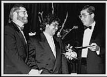 Eddie Schwartz debout avec deux hommes non identifiés en smoking [between 1990-1995].