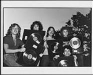 SAGA holding album awards for "Worlds Apart" [ca 1982].