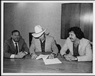 Ian Tyson signant un contrat d'enregistrement avec CBS Canada, (de gauche à droite) Bernie Dilate (président, CBS Records Canada), Ian Tyson, Jeff Burns (vice-président d'A&R) [ca. 1984].