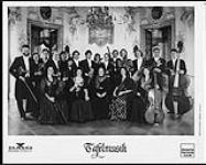 Publicity portrait of Tafelmusik in a ballroom, holding instruments and wearing formal dress [entre 1989-1990].