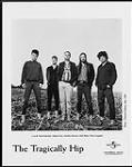 Publicity portrait of The Tragically Hip standing barefoot in a field - (left to right) Gord Sinclair, Johnny Fay, Gordon Downie, Rob Baker, Paul Langlois May, 1998