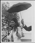 Shania Twain parlant au microphone à l'extérieur sous un parapluie [between 1995-1998].