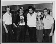 (de gauche à droite) Terry Carson (RCA), Robin Ingram (directeur musical, CFAC), Waylon Jennings, Pam Barker (correspondant, Country Music News), Mike Pleau (RCA), au Olympic Saddledome, à Calgary [entre 1980-1985].