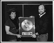 Billy Joel reçoit un disque platine à l'Edmonton Coliseum : (de gauche à droite) Billy Joel, Dave Dargie (directeur, Région de l'Ouest, CBS Records Canada) [ca.1982].