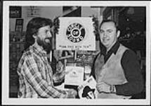 Rick Laufler, propriétaire du Circle of Sound dans le County Fair Mall, à Smiths Falls, organisant une annonce pour promouvoir la nouvelle chanson « Payfairville » de Jim Rae [between 1979-1980].