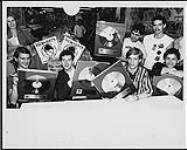 Men Without Hats reçoit des disques d'or pour Rhythm of Youth au Flipside Records, à Toronto, le 10 juin. De gauche à droite : Ivan, Allan McCarthy, Stefan Doroschuk et Colin Doroschuk (assis). Marc Durand (gérant) et Chris Allicock de Wea (debout) [entre 1982-1989]