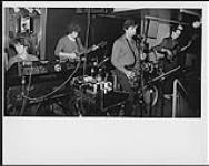 Le Rick Morrison Project se produit au Café on the Park. De gauche à droite : Dave MacMorrow, Earl Marek, Rick Morrison, Vito Rezza (batterie) et Dave Trevis [entre 1982-1983].