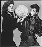 Martha Johnson and Mark Gane, members of M+M, holding a globe between them [between 1983-1986].