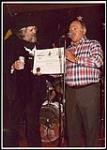 Don Tyson, U.S. Chicken magnet, représentant du gouvernement, présentant à Ronnie Hawkins un Arkansas Traveler Certificate [entre 1975-1982].
