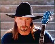 Rick Tippe portant un chapeau de cowboy et tenant une guitare [between 1994-1998].
