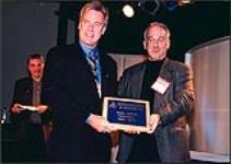 1050 CHUM FM's Ross Davies receives an Ontario Association of Broadcasters award from Don Shafer of Toronto Star TV 2000