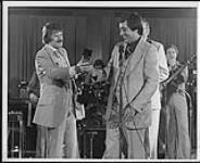 Dallas Harris presents Bill Anderson with an award on stage [between 1970-1975].