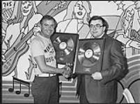Jury Krytiuk et un homme non identifié exhibant chacun un disque d'or [entre 1971-1975].