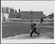 Brian Robertson lance une balle de baseball [between 1980-1985].