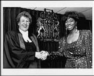 After Vivienne Williams sings the national anthem for the Hamilton Citizenship Court,  Judge Jean Gerrie congratulates her and  wishes her good luck on her upcoming album release [entre 1985-1992].