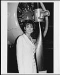 Michelle Wright standing by the propellor of an unidentified aircraft [between 1993-1996].