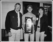 Bryan White holding an award while standing with two unidentified people [ca 1996].