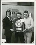 Michel Lefebvre and Robert Arcand of CKLM, standing with Quality Records' Barry Stafford [ca 1978].