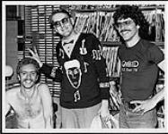 Rob Braide and Bob Beauchamp of CHOM FM, pose with Rick Nielson of Cheap Trick [between 1978-1980].