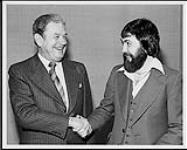 Donald H. Hartford of Standard Broadcasting, shakes hands with Jim Long of TM Productions after signing a joint production agreement [ca. 1975].