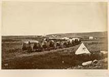 Wagon train moving towards a camp, near Frenchman Creek (a tributary of Milk River), Saskatchewan, July-August 1874 July-August 1874.