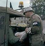 Fallex, Germany. MCpl Jim McNamee gives directions to an American officer during Exercise Carbon Edge September 1977.