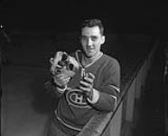 Jacques Plante des Canadiens de Montréal montrant son masque Louch lors d'une séance d'entraînement ca. 1954-1959.