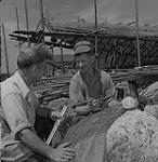 Hugh McKay (à gauche), et Bill Jackson (à droite) étudiant les plans d'un navire 1950