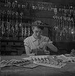 A woman works on fishing bait 1956