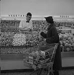 A grocer discusses mushroom with a patron 1957