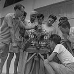 Frère Ephrem présente un moteur à combustion interne aux élèves 1957