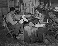 [Trois hommes David Martin, Henry Hunt, Mungo Martin, travaillent dans un atelier de menuiserie] Deux hommes travaillant à des sculptures en bois 1955