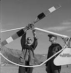 Ed Philips, à gauche, vérifiant le niveau d'huile du rotor de queue de l'hélicoptère 1960
