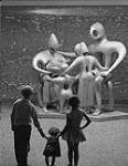 Jeunes enfants admirant une grande statue de bronze 1960