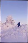 [Inuk man walking around ice formations] [between 1953-1969]
