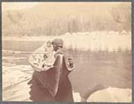 [Two children (possibly Tlingit) in a dugout canoe on the water, Southeast Alaska]. Original title: Indian canoe, S.E. Alaska [between 1900-1910].