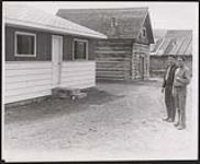 [Two men posing outside of a home built under the Federal subsidy plan in Williams Lake, BC] [between 1945-1960]